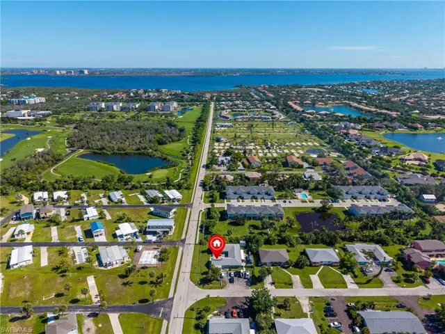 View of property location featuring a large body of water, nearby suburban area, and a local golf course