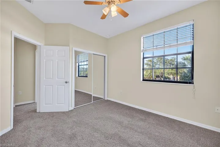 Unfurnished bedroom with a closet, carpet floors, and a ceiling fan