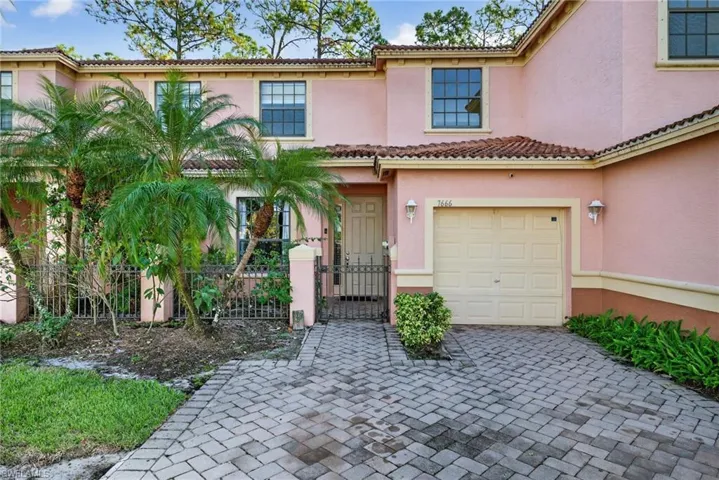 Mediterranean / spanish-style home featuring stucco siding, a gate, a fenced front yard, a garage, and a tile roof