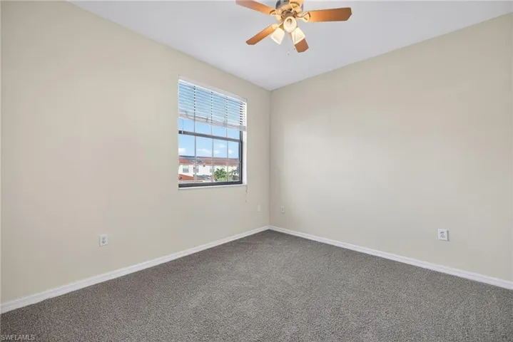 Empty room with carpet flooring and ceiling fan