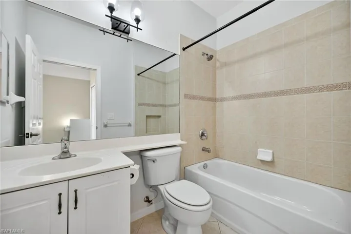 Full bathroom with shower / tub combination, vanity, and light tile patterned floors