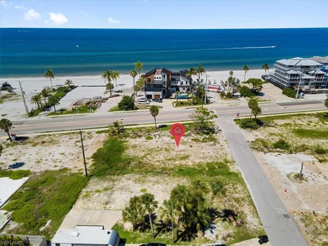 Birds eye view of property with a water view and a view of the beach