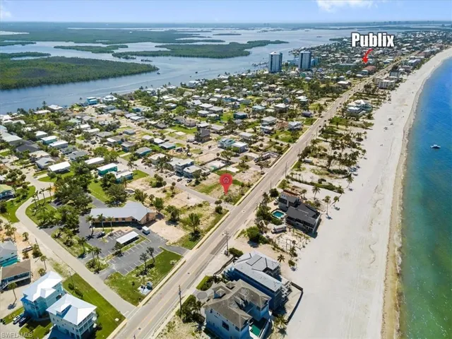 Birds eye view of property featuring a water view and a view of the beach