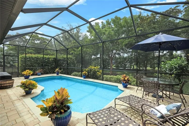 View of swimming pool with a patio area and screened enclosure.