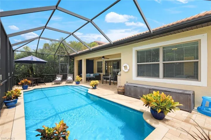 View of pool featuring a patio, ceiling fan, and screened enclosure
