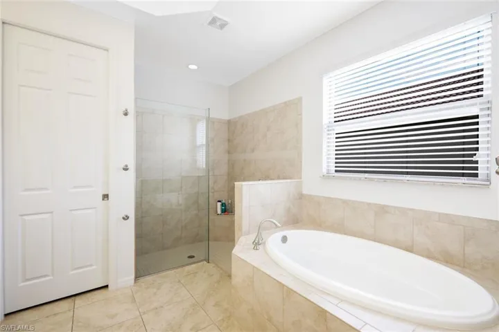 Bathroom featuring independent shower and bath and tile patterned floors