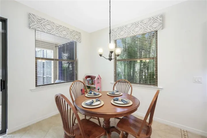 Dining space featuring light tile patterned flooring, an inviting chandelier, and plenty of natural light