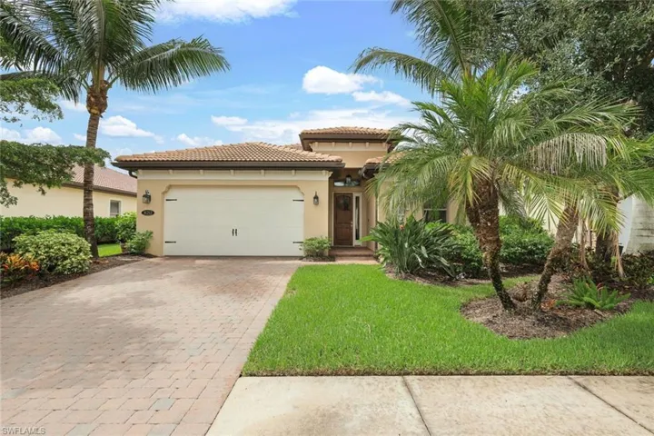 Beautifully landscaped front yard with paver driveway