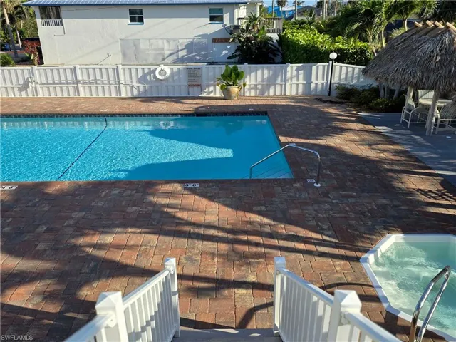 Community pool with a fenced backyard and a patio