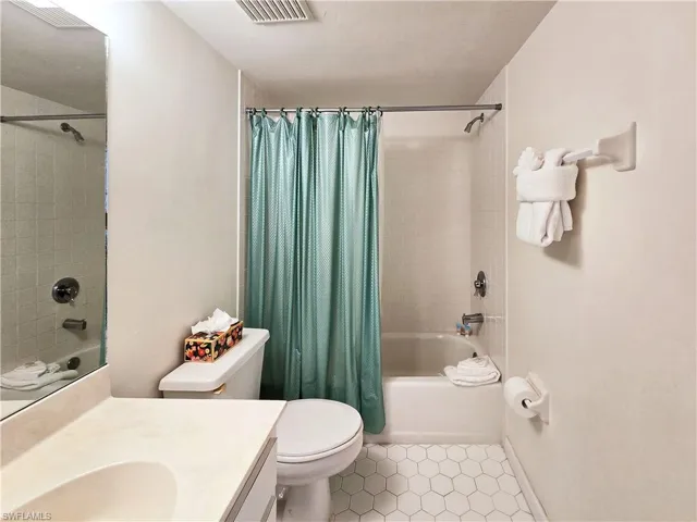 Second bathroom featuring vanity, shower / tub combo, and tile patterned floors