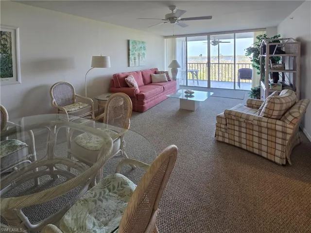 Living area featuring ceiling fan, carpet floor and sliding door windows