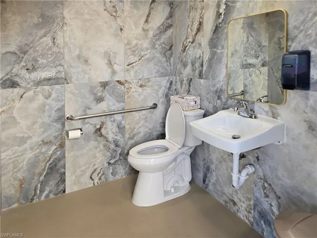 Bathroom with toilet and tile walls at the pool area