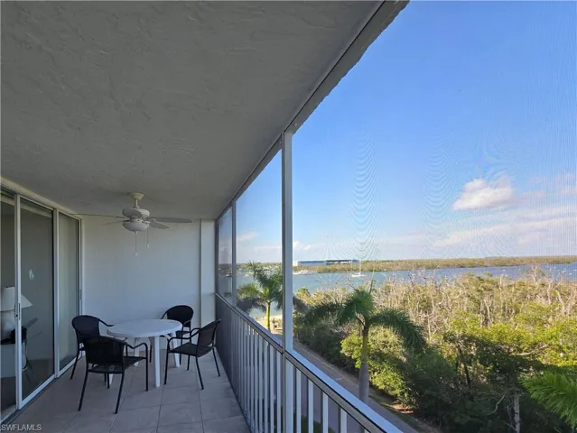 Balcony featuring a water view and a ceiling fan
