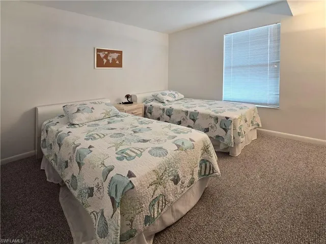 Carpeted bedroom with 2 beds and a closet