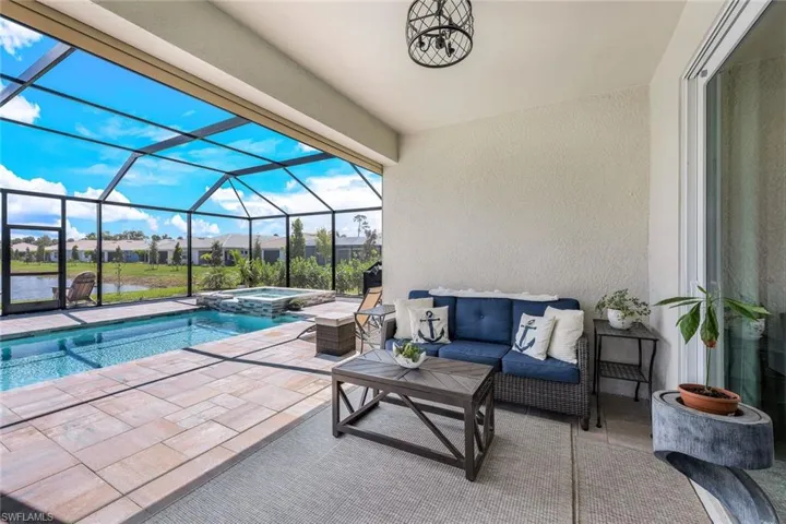 View of swimming pool featuring outdoor lounge area, a lanai, an in ground hot tub, and a patio