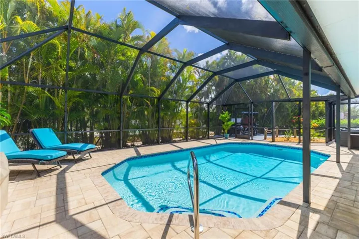 Outdoor pool featuring a patio area, glass enclosure, and a sunroom