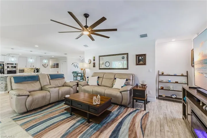 Living area with recessed lighting, light wood finished floors, and a ceiling fan
