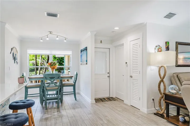 Dining area with light wood finished floors and ornamental molding