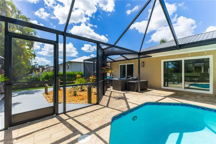 Swimming pool featuring glass enclosure, a sunroom, and a patio area