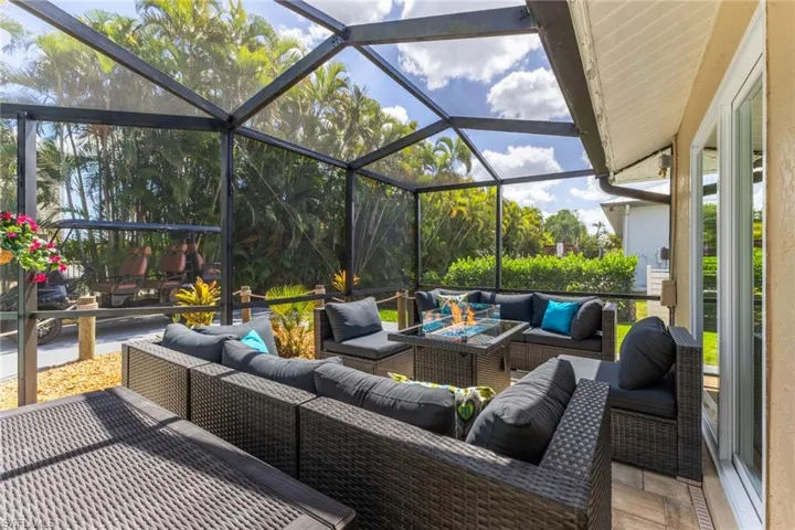 View of patio with a sunroom, outdoor lounge area, and glass enclosure