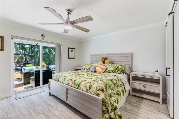 Bedroom featuring access to exterior, light wood-style floors, crown molding, and ceiling fan
