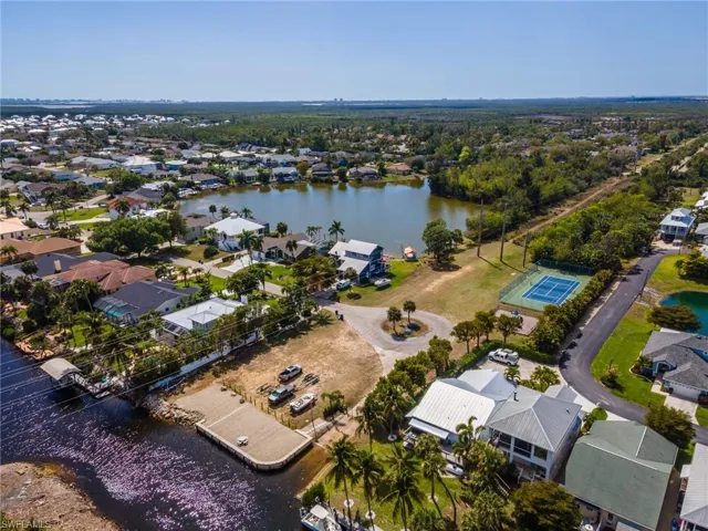 Aerial view of property and surrounding area with nearby suburban area and a large body of water