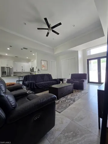 Spacious open-concept living area featuring large format tile flooring, a contemporary ceiling fan, and recessed lighting