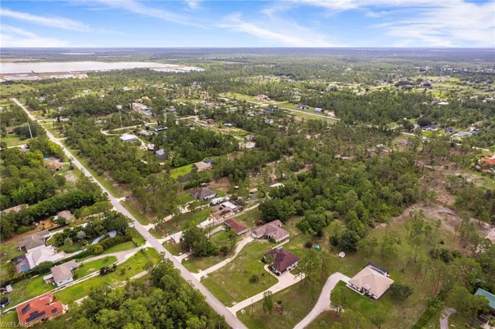 Expansive aerial perspective showcasing a residential area with varied housing styles and extensive natural tree coverage