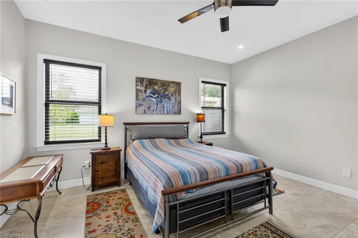 Bedroom featuring light gray walls, two windows with blinds, a ceiling fan, and recessed lighting