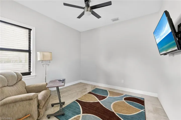 Room featuring light-toned walls, tile flooring, and a ceiling fan with integrated lighting
