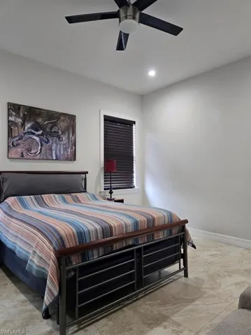 Spacious room featuring neutral wall tones, recessed lighting, a modern ceiling fan, and tile flooring