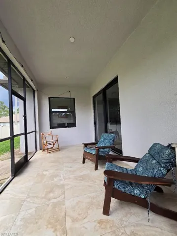 Screened patio featuring large format tile flooring, recessed ceiling lighting, and direct access to interior spaces through sliding glass doors