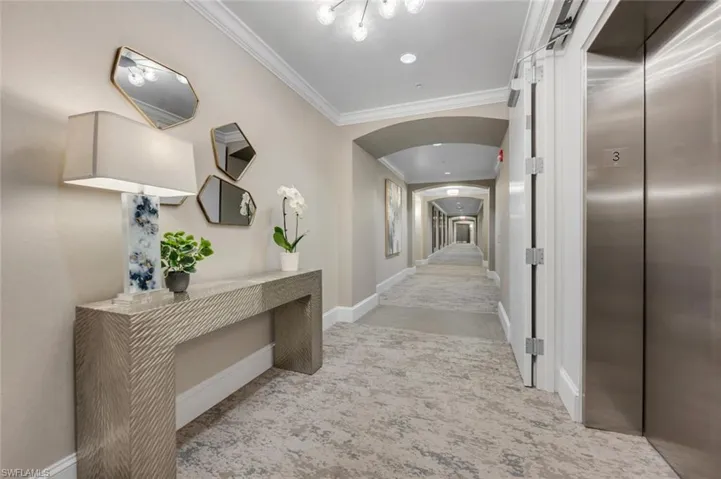 Corridor featuring elevator and ornamental molding