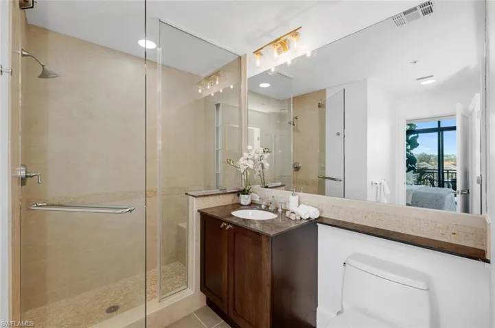 Bathroom featuring tile patterned floors, vanity, and an enclosed large shower