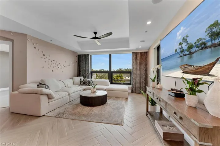 Living room w/lots of natural light, raised ceiling, updated window treatments, impact resistant windows and freshly painted walls
