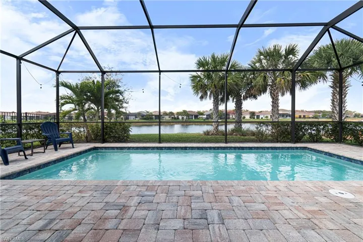 View of swimming pool featuring a patio, a water view, and screen enclosure
