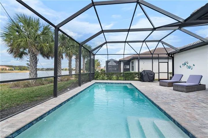 View of swimming pool featuring a water view, area for grilling, and screen lanai