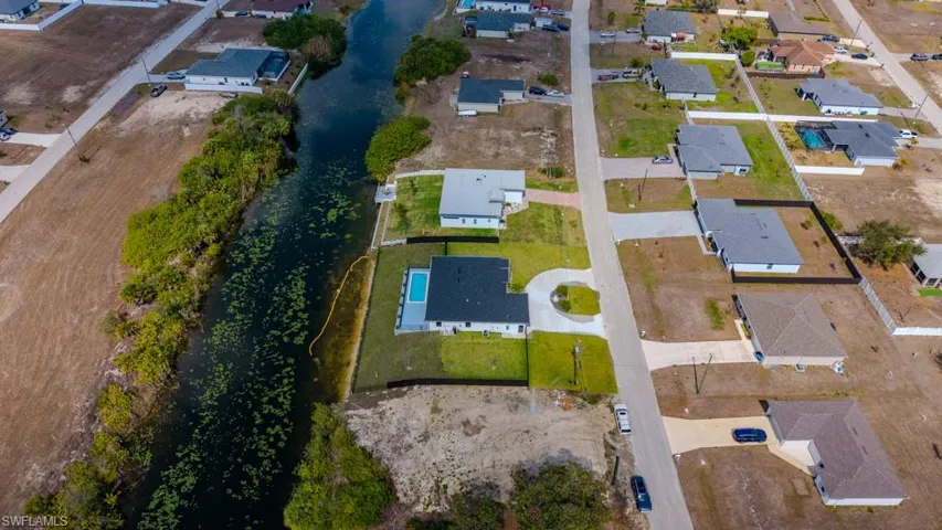 Aerial view of property and surrounding area featuring nearby suburban area