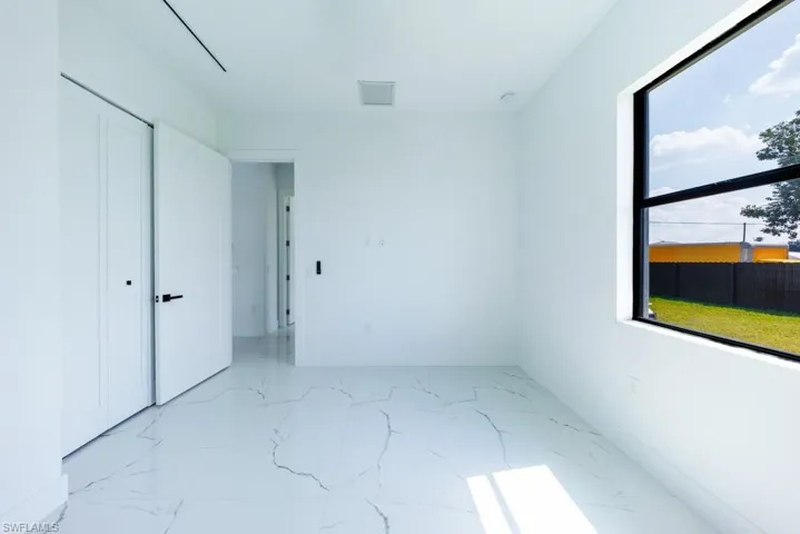 Unfurnished bedroom with baseboards and light marble finish flooring