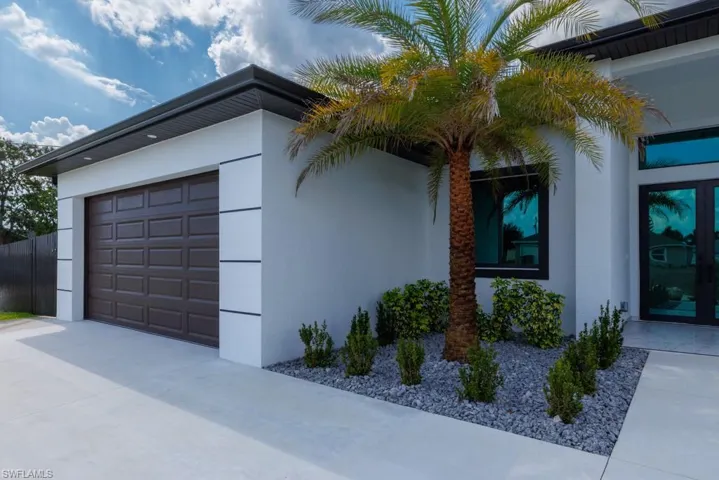 View of home's exterior featuring stucco siding, concrete driveway, and an attached garage