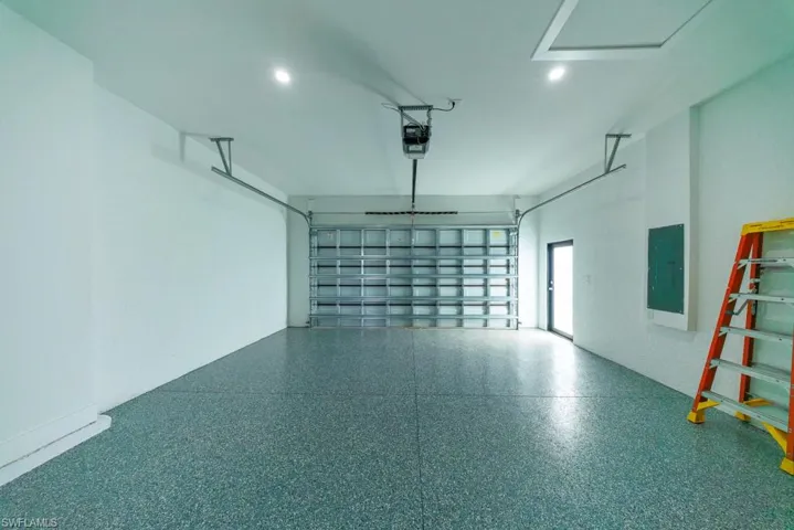 Garage featuring electric panel and recessed lighting