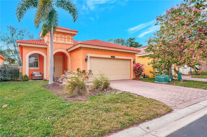 Mediterranean / spanish-style house featuring a front lawn and a garage