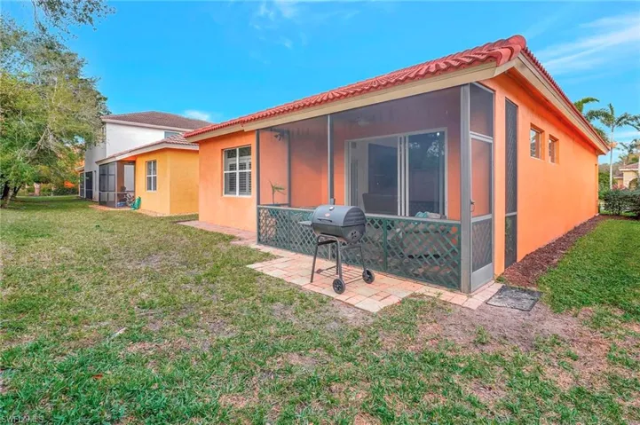 Rear view of house with a lawn and a sunroom