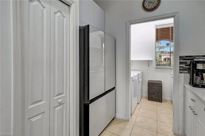 Bathroom with tile patterned flooring, washing machine and dryer, and tasteful backsplash