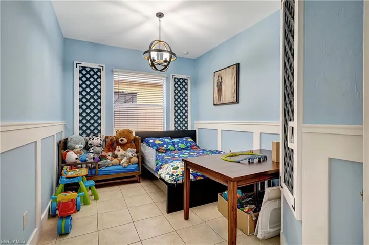 Bedroom featuring an inviting chandelier and light tile patterned floors