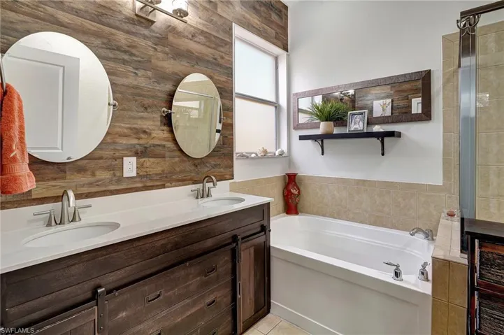Bathroom with tile patterned floors, vanity, and a bathing tub