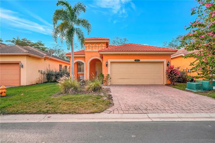 Mediterranean / spanish home with a garage and a front lawn