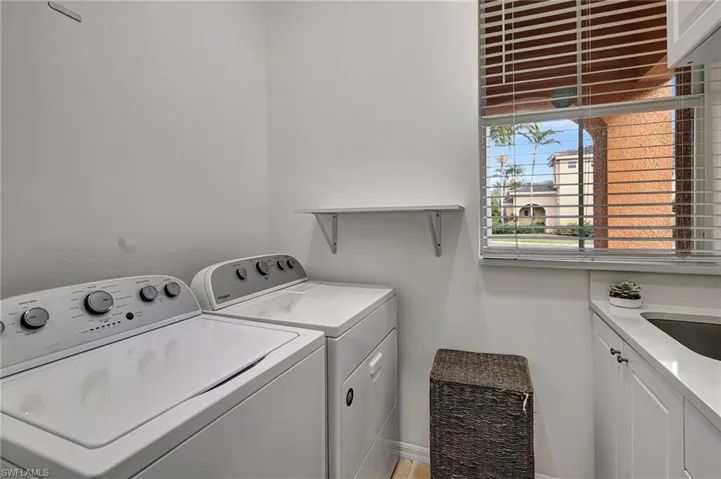 Laundry room featuring sink, cabinets, and independent washer and dryer