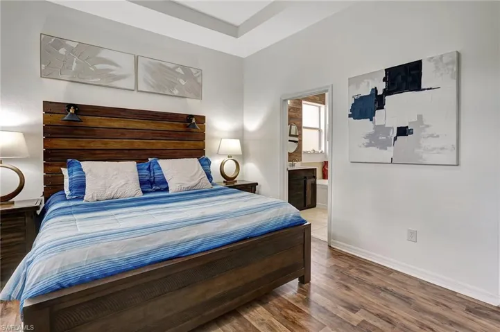 Bedroom with ensuite bathroom and wood-type flooring