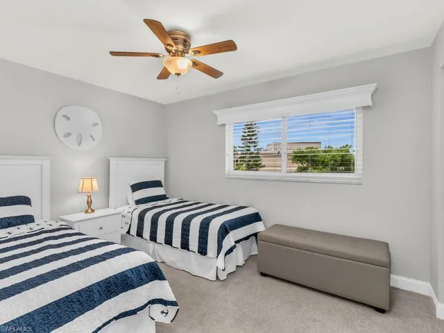 Bedroom with ceiling fan and light colored carpet